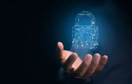 A close-up image of an outstretched hand holding a glowing digital padlock icon composed of interconnected lines and nodes. The padlock is illuminated against a dark blue background, symbolising cyber security, data protection, and digital resilience.